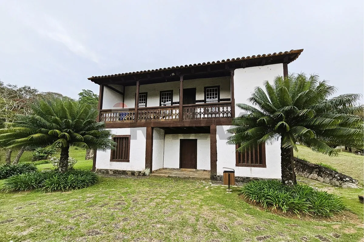 Casarão histórico da sede da fazenda, cercado de palmeiras